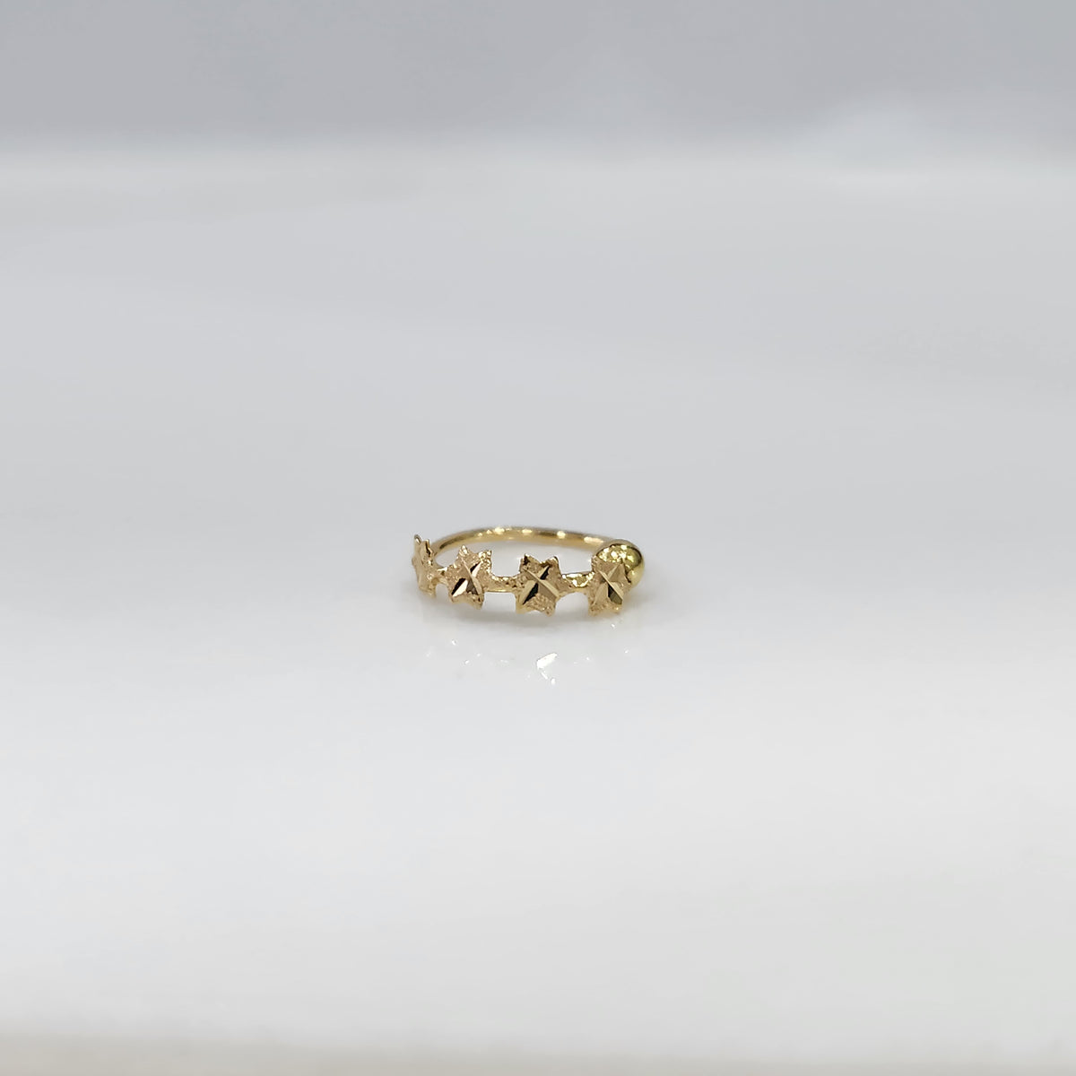 Stars Prism gold nose ring crafted in 18K gold with star-shaped pattern, elegant and minimal design displayed on plain background