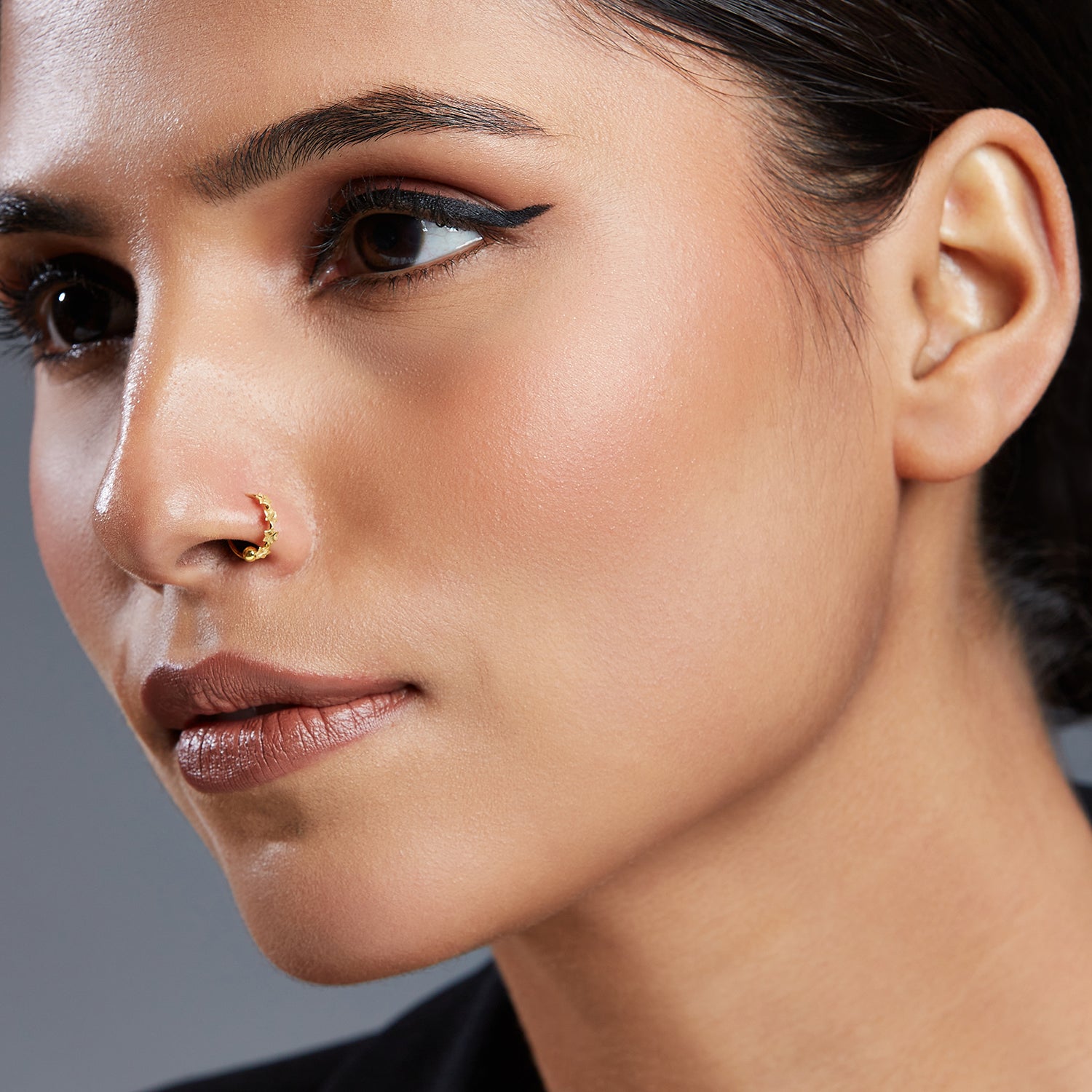 Model wearing Stars Prism gold nose ring in 18K gold, designed with star-shaped details for a cosmic and stylish look