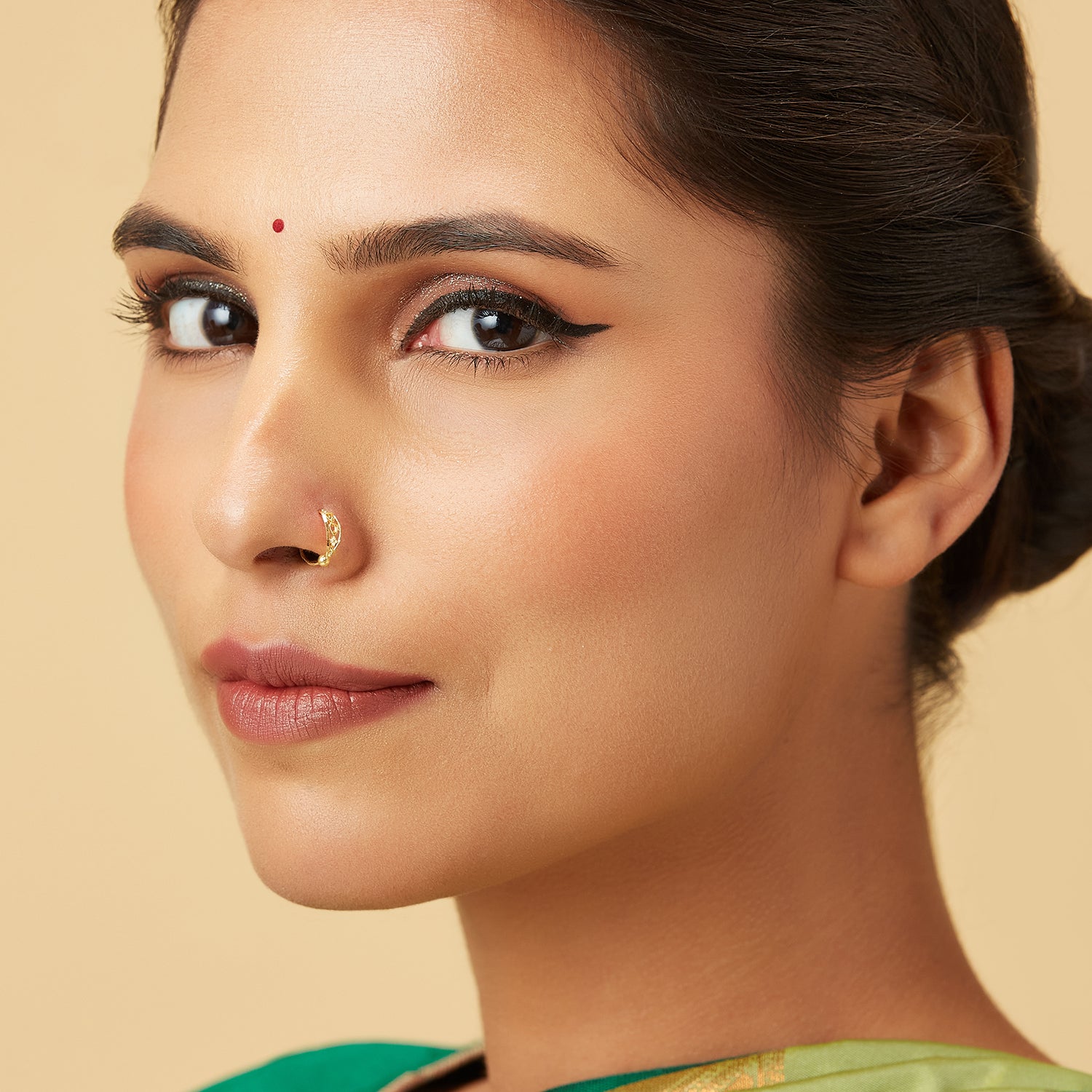 Model wearing Twist Blossom Gold Nose Ring in 18K gold with floral petal and vine twist design by Yuvora