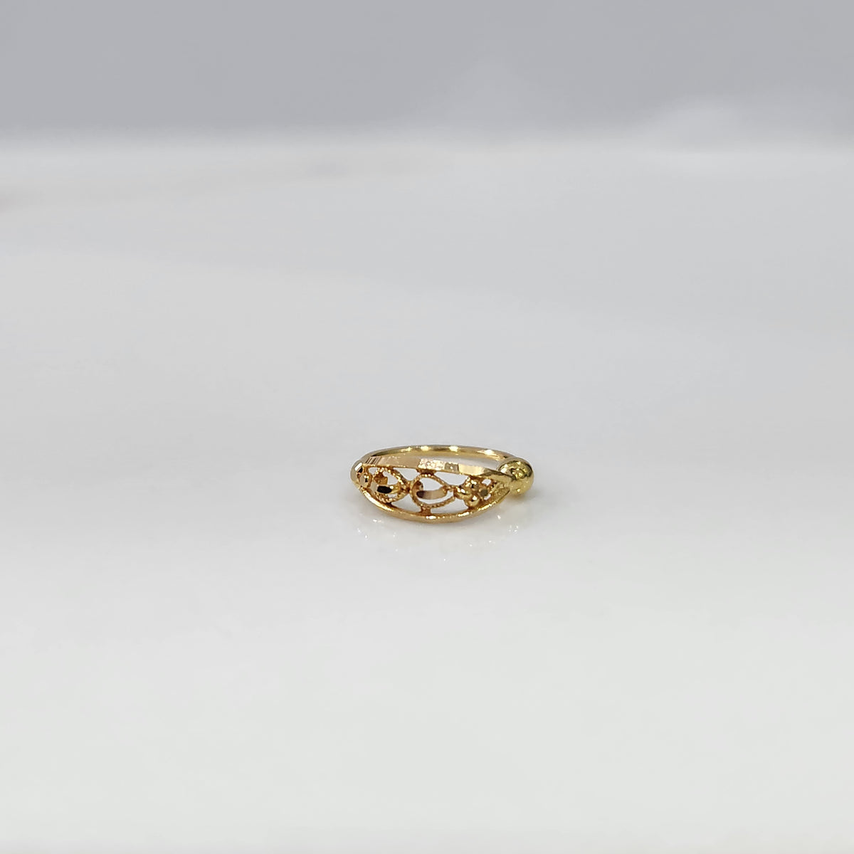Twist Blossom Gold Nose Ring in 18K gold with floral and twisted vine design placed on a white background by Yuvora