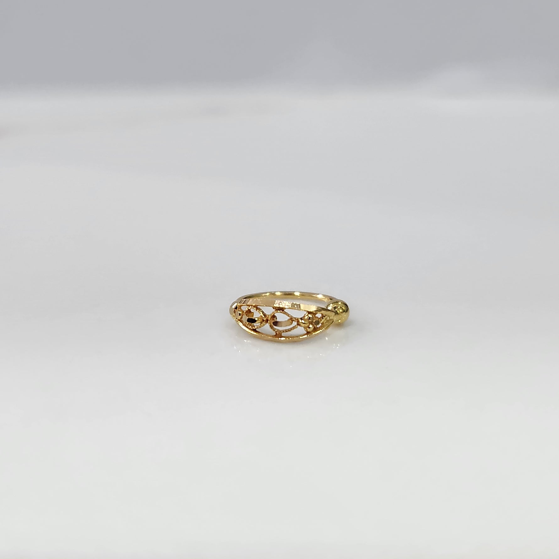 Twist Blossom Gold Nose Ring in 18K gold with floral and twisted vine design placed on a white background by Yuvora