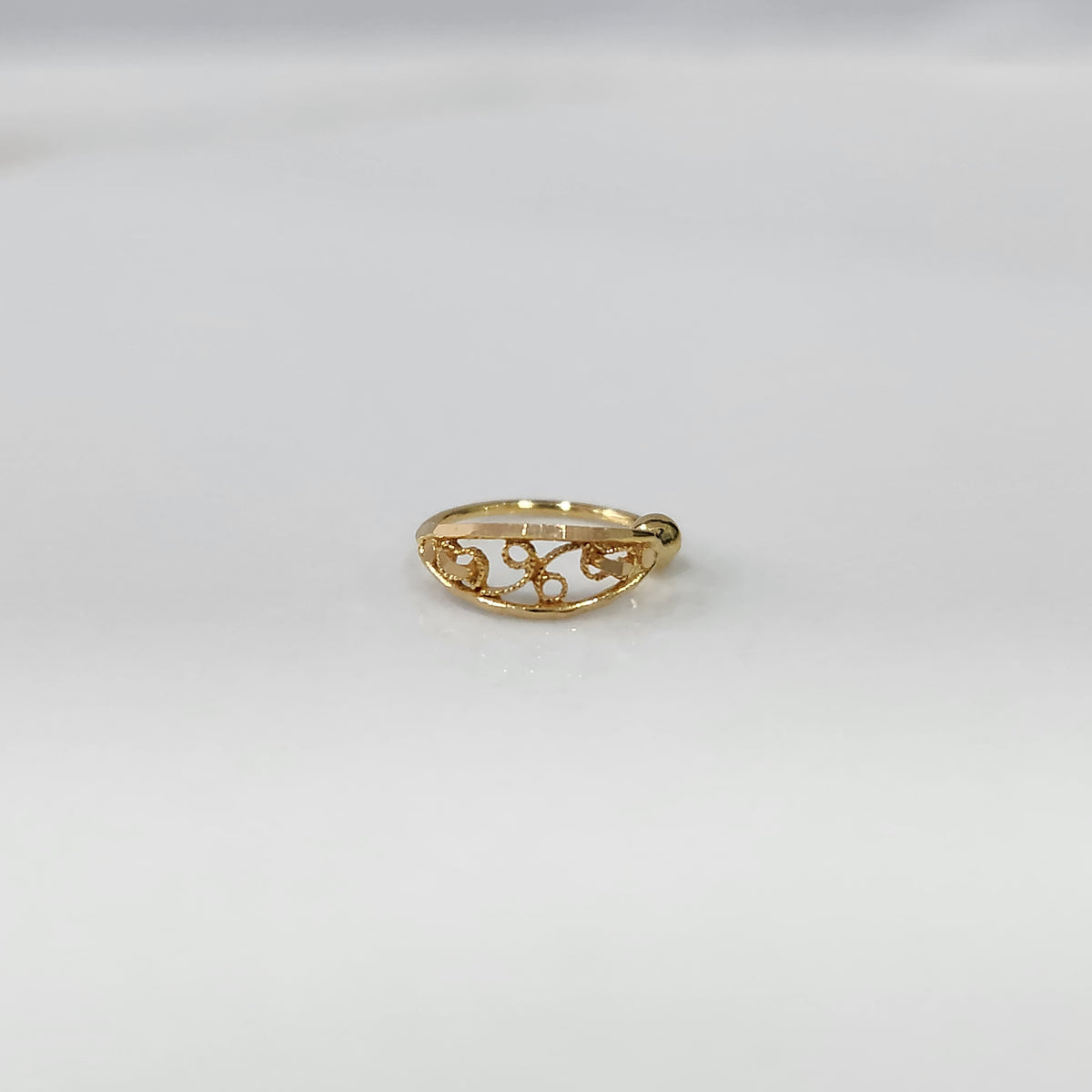 Vine Loop Gold Nose Ring in 18K gold with elegant filigree vine design displayed on a plain background by Yuvora
