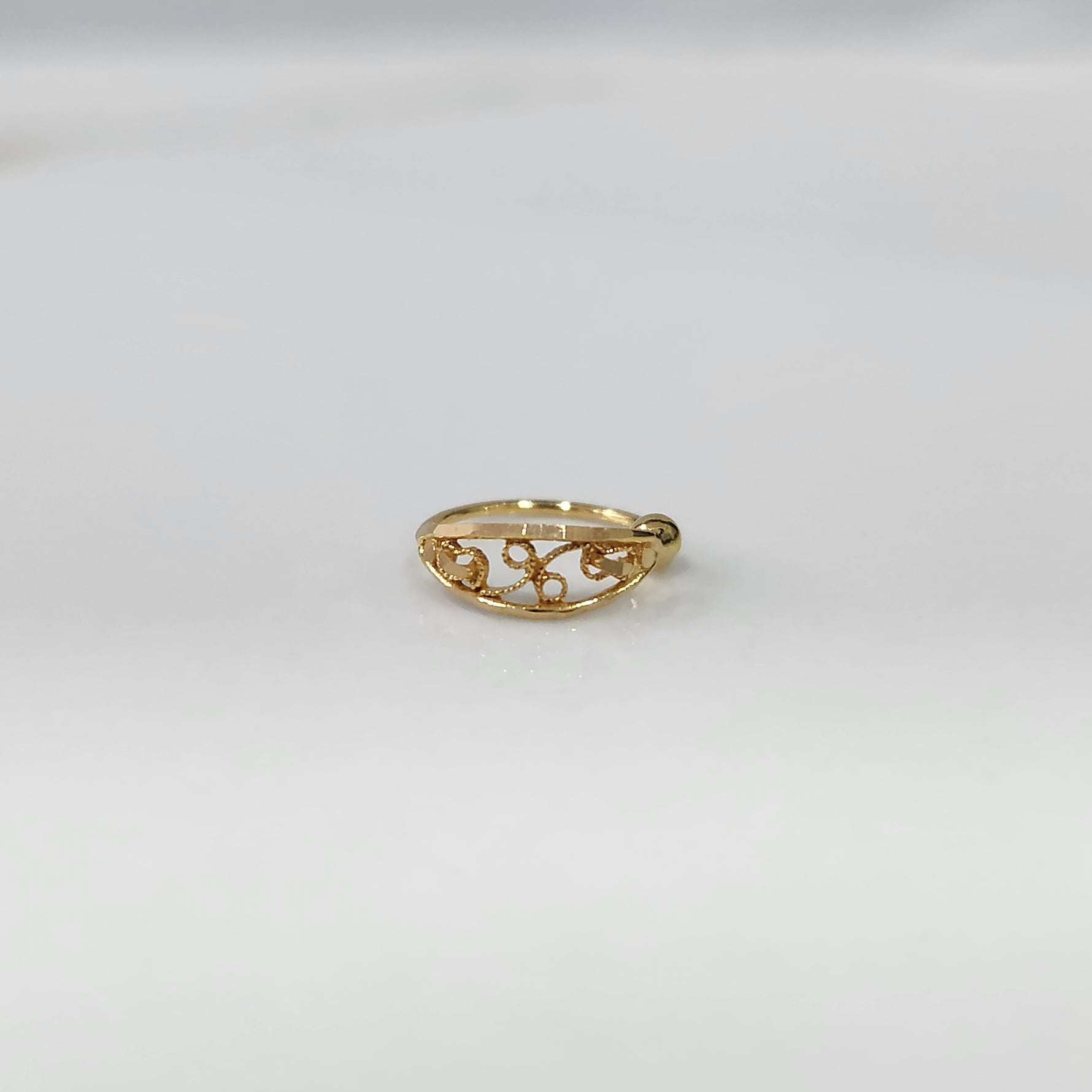 Vine Loop Gold Nose Ring in 18K gold with elegant filigree vine design displayed on a plain background by Yuvora